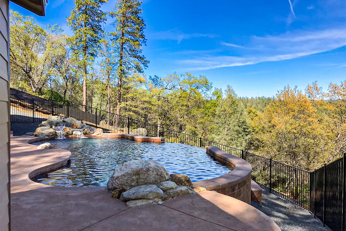 Colfax vanishing edge pool on a steep Sierra hillside — full build series documented by Jim Chandler Pools