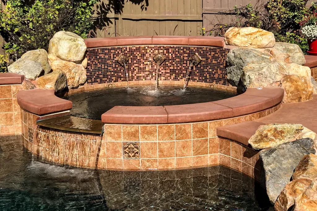 Custom gunite spa with natural stone coping and mosaic tile water feature, Lincoln, California.