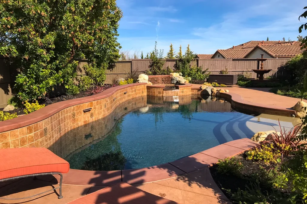 Wide view of custom pool and spa with natural stone accents and mosaic tile, Lincoln, California