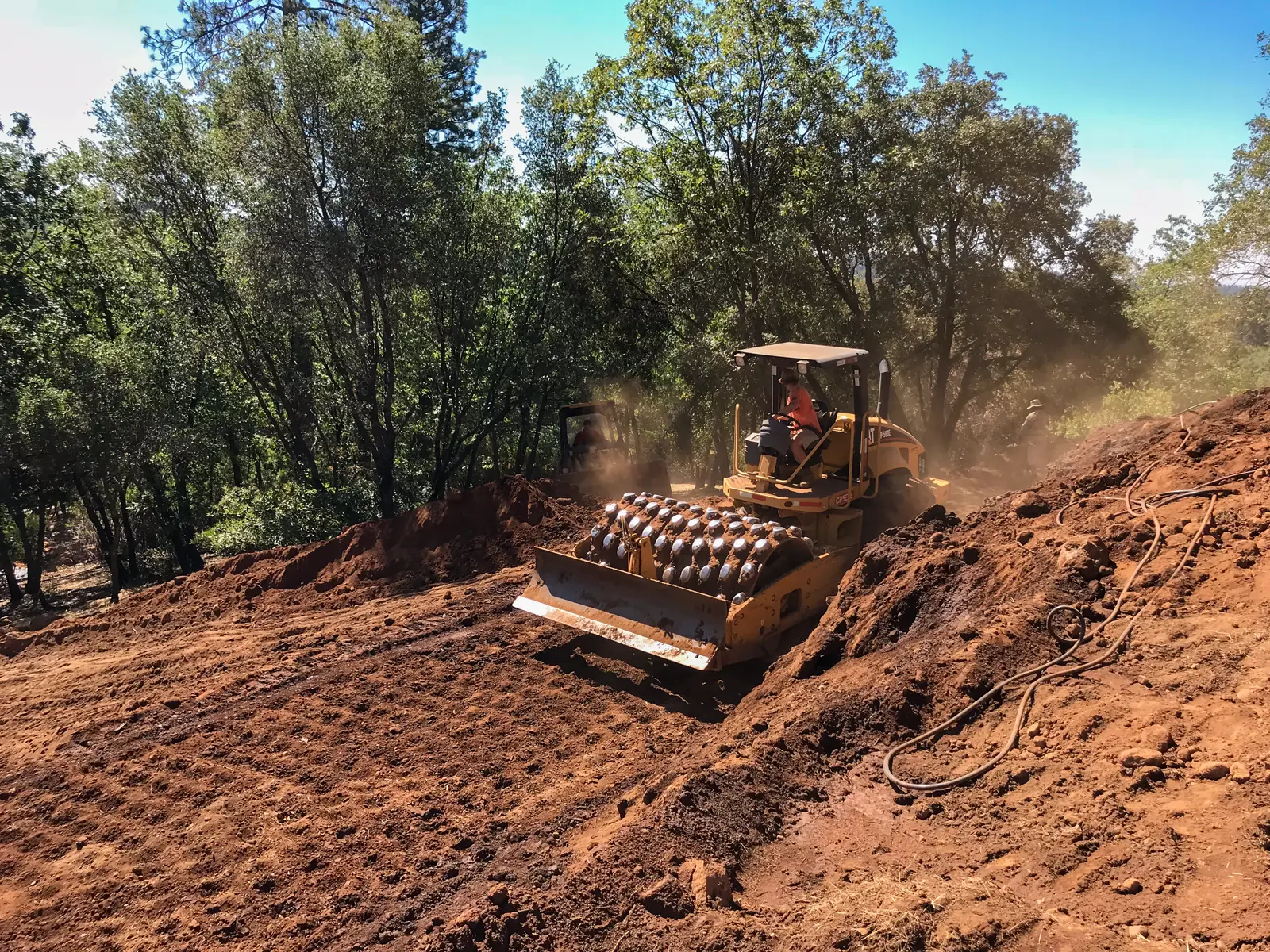 Engineered fill compaction on a steep hillside during vanishing edge pool construction in Colfax California