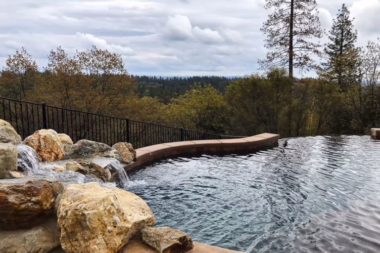 Vanishing edge pool with natural boulder waterfall overlooking the Sierra foothills.