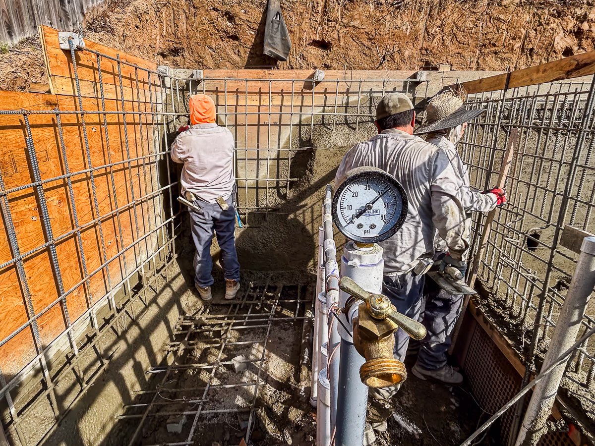 Gunite crew at structural retaining wall with pressure gauge reading 41 PSI during small yard pool construction in Rocklin CA