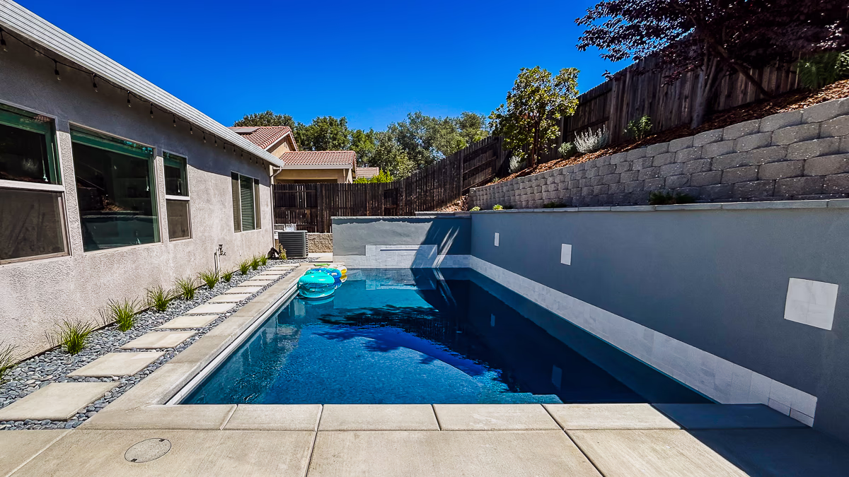 Finished small yard pool with gunite retaining wall and hillside in Rocklin CA backyard