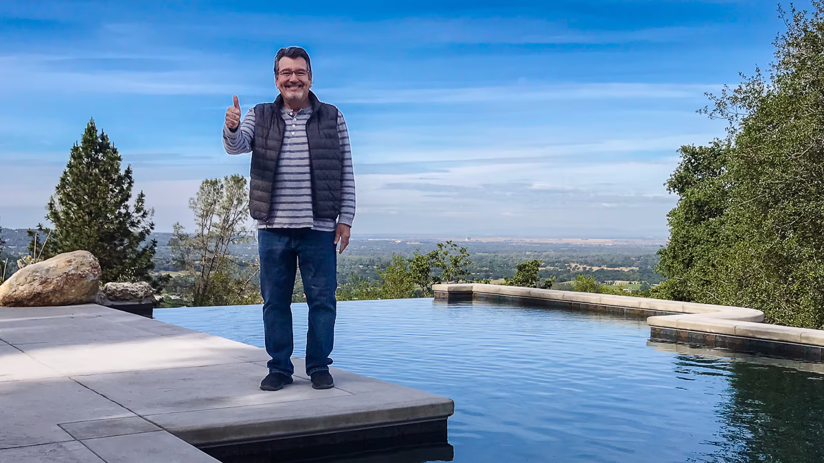 Jim Chandler, custom pool builder, on site at Auburn hillside vanishing edge pool with Sacramento valley views