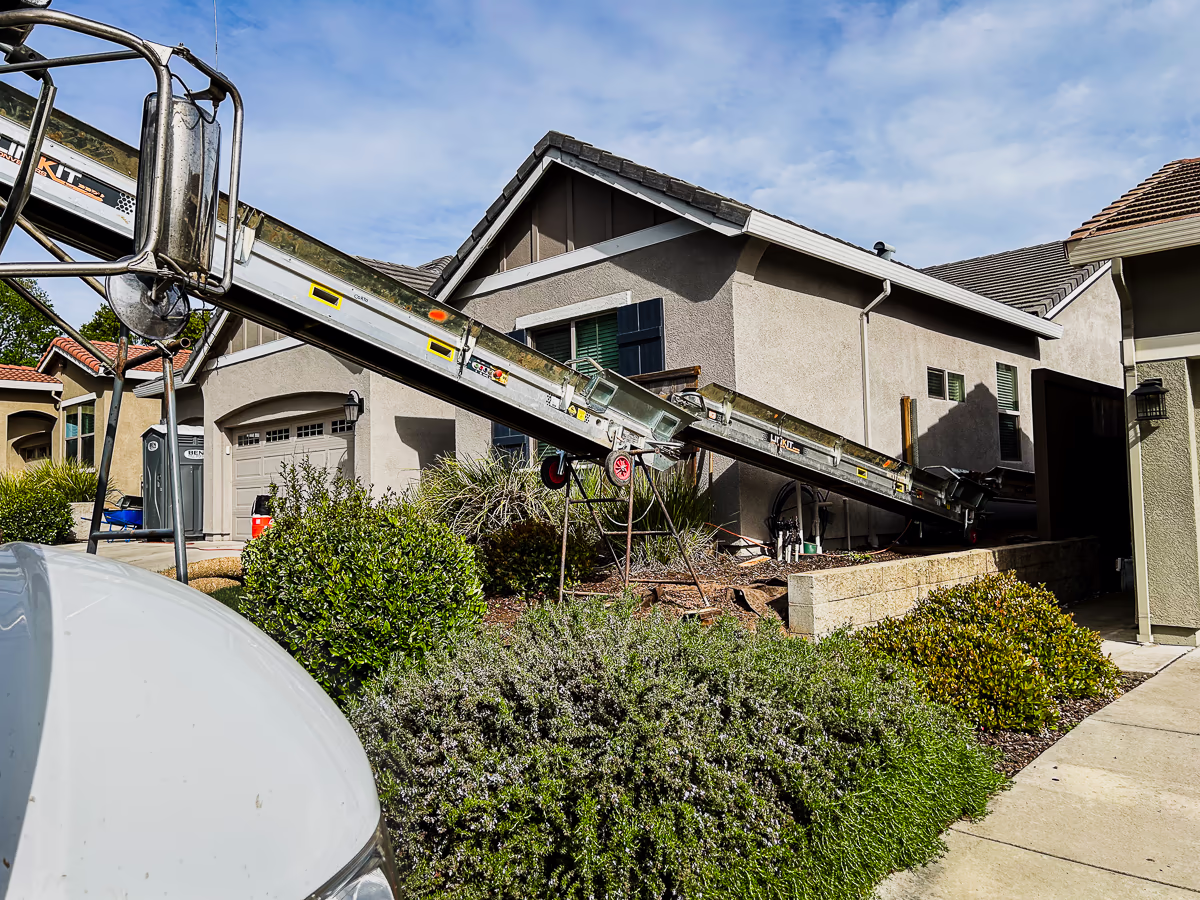 Linkit conveyor belt discharging soil at street level during pool excavation in Rocklin CA