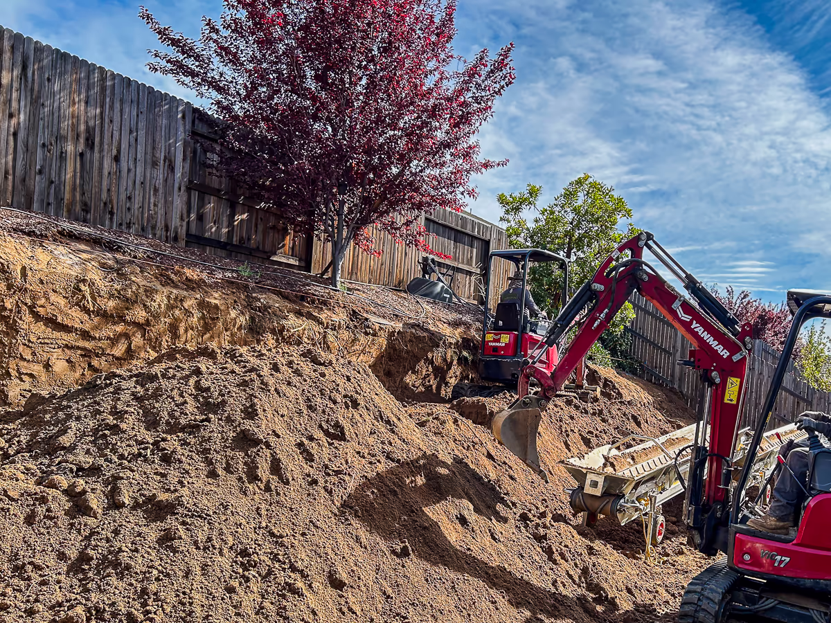 Yanmar mini excavator feeding conveyor from backyard excavation in Rocklin CA