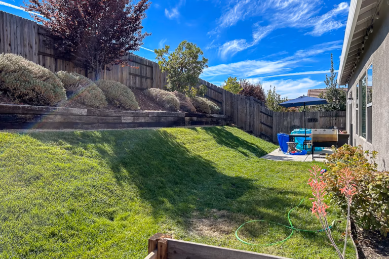 Steep backyard slope with existing retaining walls before custom pool construction in Rocklin, California