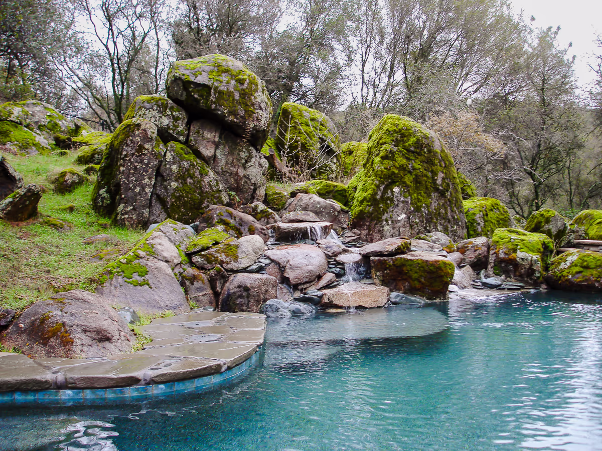 Cascading waterfall over moss-covered granite boulders into river pool in Sierra foothills of Placer County by Jim Chandler Pools
